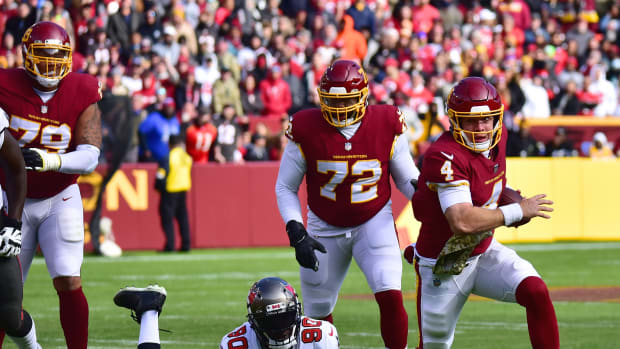Washington Football Team quarterback Taylor Heinicke runs away from Tampa Bay Buccaneers defensive lineman Jason Pierre-Paul